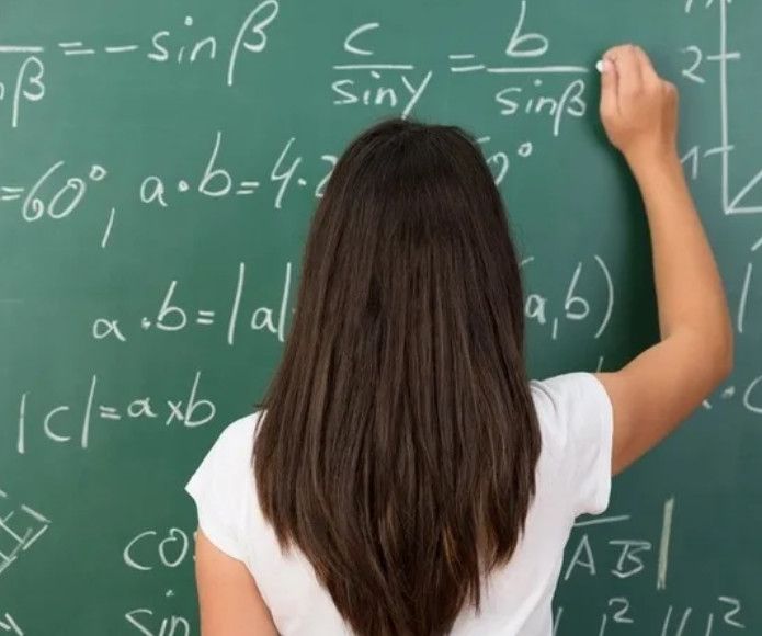 Девушка решает математику у доски